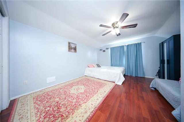 bedroom featuring a ceiling fan, vaulted ceiling, baseboards, and wood finished floors