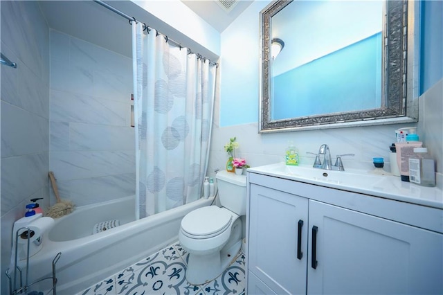 bathroom with shower / bath combo, toilet, tile patterned floors, vanity, and tile walls