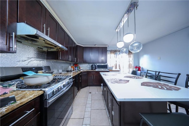 kitchen with dark brown cabinetry, stainless steel gas range oven, tasteful backsplash, a kitchen island, and under cabinet range hood