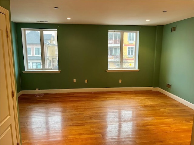 spare room with light wood finished floors, visible vents, baseboards, and recessed lighting