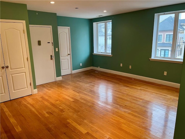 spare room with light wood-style floors and baseboards