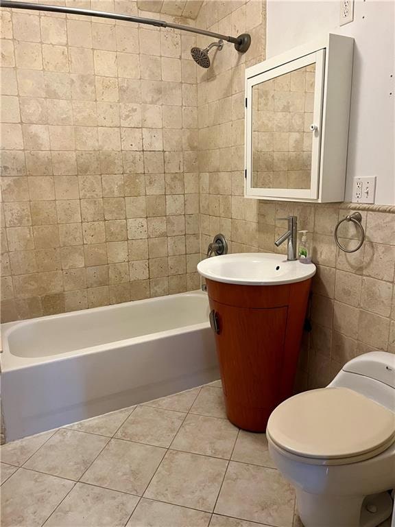 bathroom with tile patterned flooring, shower / bathing tub combination, tile walls, and toilet