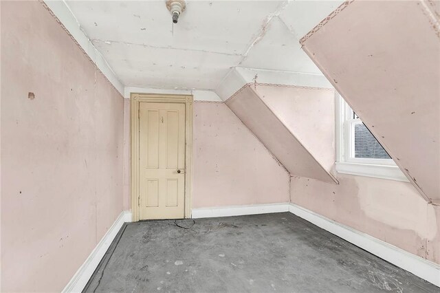 additional living space with concrete flooring and vaulted ceiling