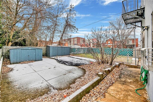 view of yard with a storage shed and a patio