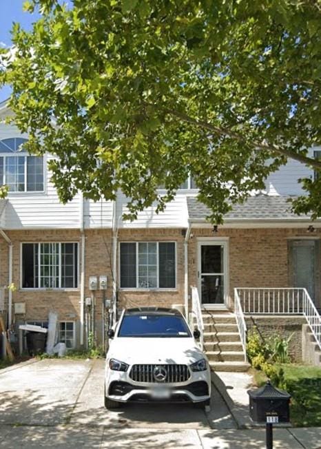 view of property with stairway and brick siding
