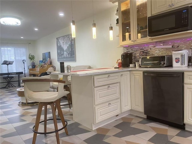 kitchen with kitchen peninsula, decorative backsplash, black appliances, and decorative light fixtures