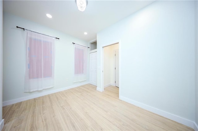 empty room with recessed lighting, baseboards, and light wood finished floors