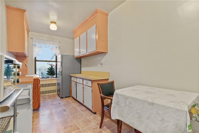 kitchen with radiator heating unit and stainless steel refrigerator