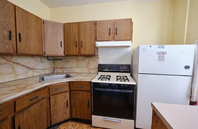 kitchen featuring decorative backsplash, white appliances, light parquet floors, and sink