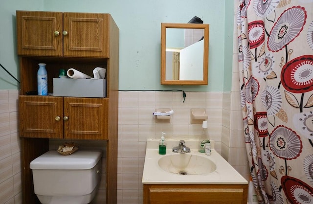 bathroom with vanity, toilet, tile walls, and walk in shower