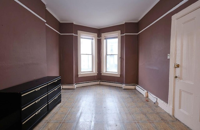 empty room featuring crown molding and a baseboard heating unit