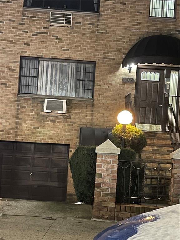 view of side of home featuring an attached garage and brick siding