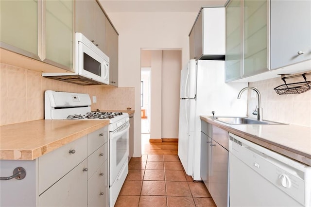 kitchen featuring light tile patterned flooring, white appliances, backsplash, and sink