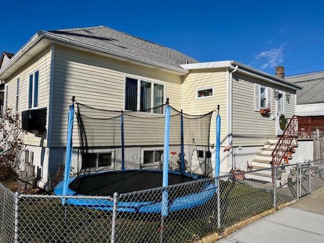 rear view of house featuring a trampoline