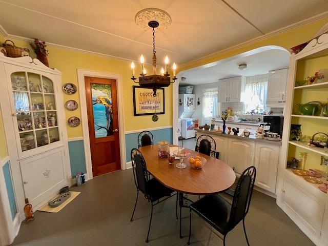 dining space featuring ornamental molding and a notable chandelier