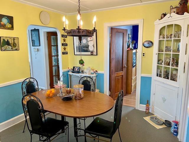 dining space with a notable chandelier and ornamental molding