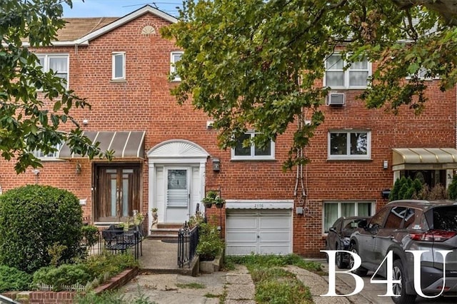 view of property featuring an attached garage, entry steps, and brick siding