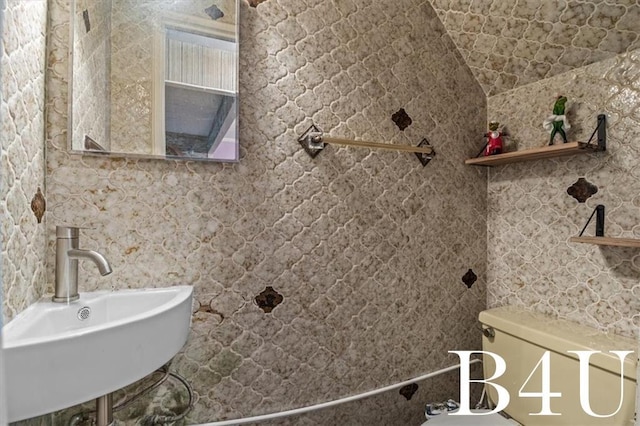 bathroom with vaulted ceiling and a sink