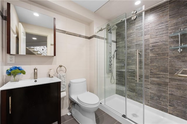 full bath with tile walls, toilet, a shower stall, vanity, and tile patterned floors