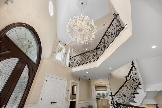 entryway featuring arched walkways, an inviting chandelier, a towering ceiling, and stairs