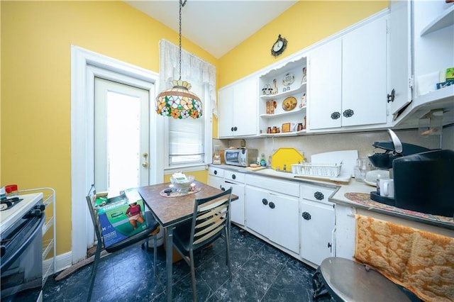 kitchen featuring white appliances, pendant lighting, and white cabinetry