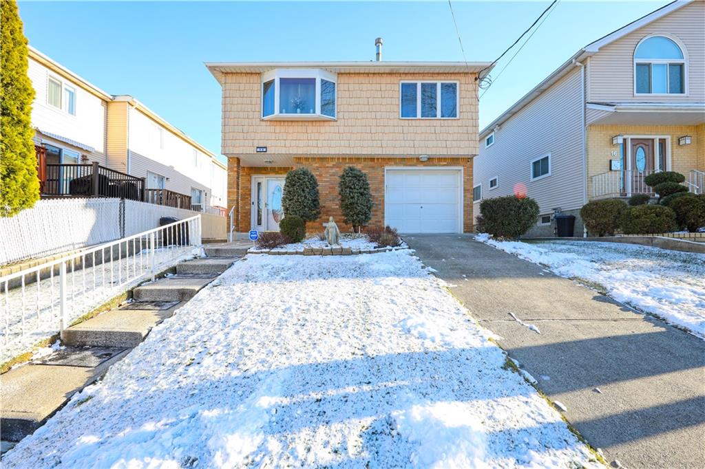 view of front of house with driveway, fence, and a garage