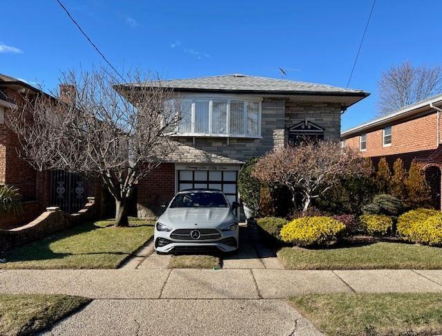 view of front of property with a garage and a front lawn