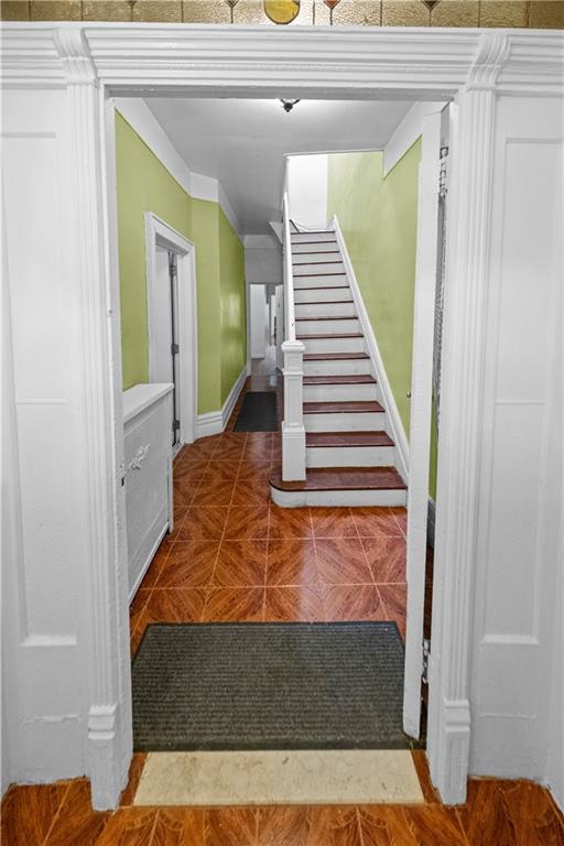 stairway featuring parquet floors and crown molding