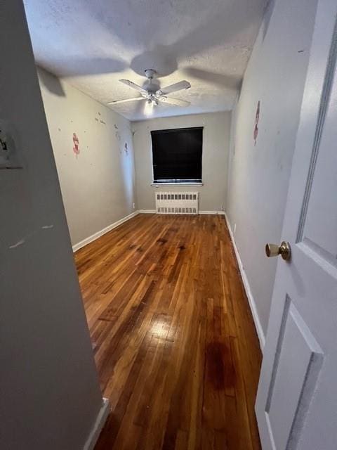 1241 E 98th St, Brooklyn, NY 11236 - unfurnished bedroom featuring radiator heating unit, wood-type flooring, baseboards, and ceiling fan