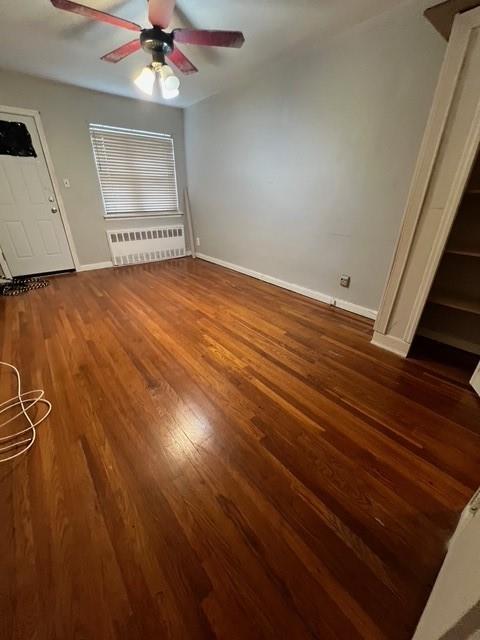 1241 E 98th St, Brooklyn, NY 11236 - unfurnished living room featuring radiator, baseboards, ceiling fan, and wood finished floors