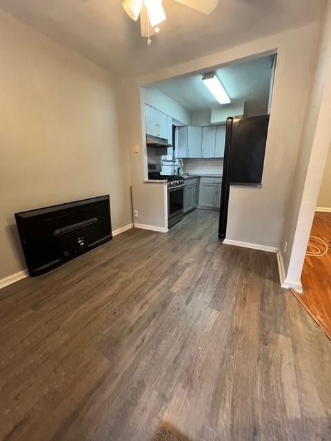 1241 E 98th St, Brooklyn, NY 11236 - unfurnished living room with dark wood finished floors, baseboards, and a ceiling fan