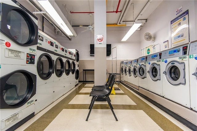 community laundry featuring stacked washer / drying machine, washing machine and clothes dryer, and a ceiling fan
