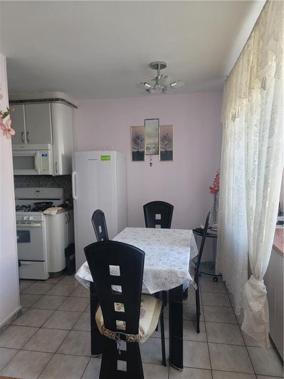 dining space with light tile patterned floors and a ceiling fan