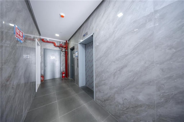 hall featuring dark tile patterned floors