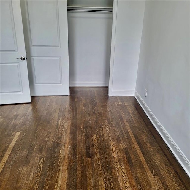 unfurnished bedroom featuring a closet and dark hardwood / wood-style floors