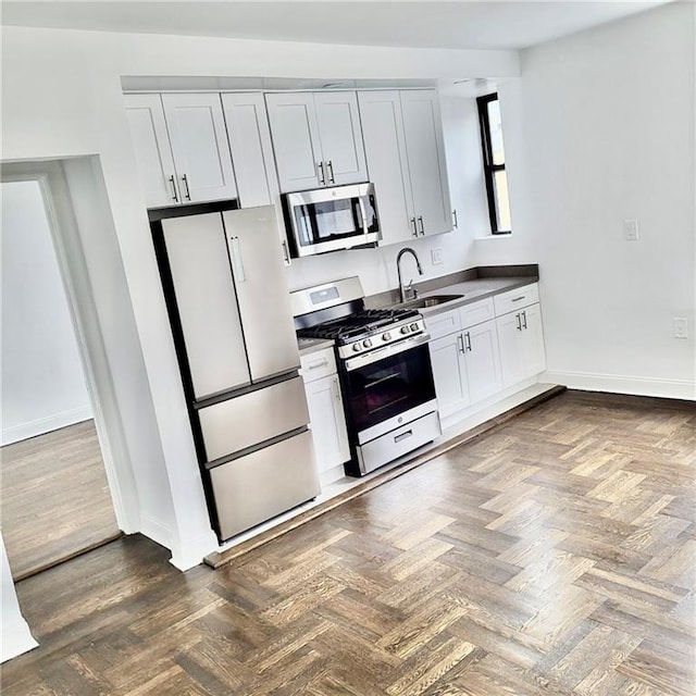 kitchen featuring white cabinetry, sink, dark parquet floors, and stainless steel appliances