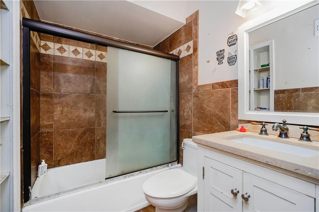 bathroom with enclosed tub / shower combo, toilet, tile walls, and vanity