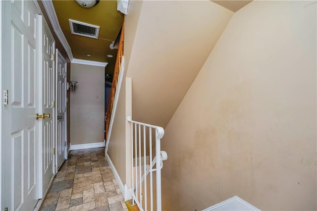 staircase with visible vents, baseboards, and stone finish floor