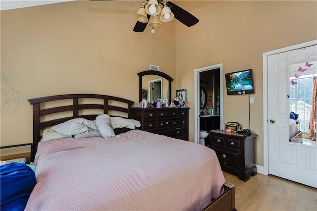 bedroom featuring light wood-style floors, a ceiling fan, visible vents, baseboards, and ensuite bathroom
