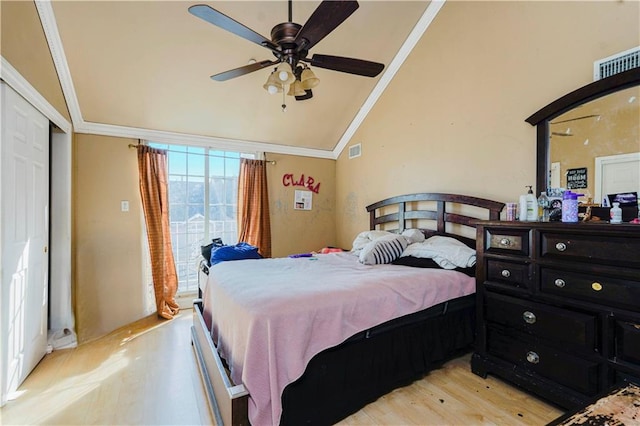 bedroom with crown molding, light wood finished floors, visible vents, and lofted ceiling