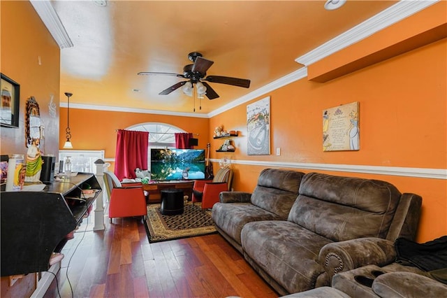 living area with ornamental molding, wood-type flooring, and ceiling fan