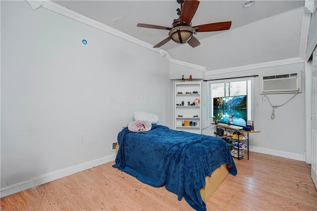 bedroom featuring wood finished floors, a wall mounted air conditioner, crown molding, and baseboards
