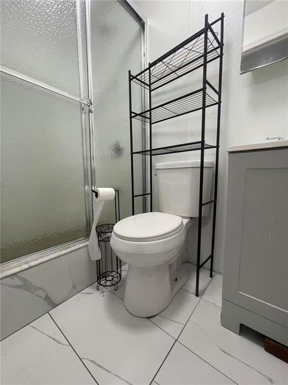 full bathroom with vanity, toilet, and bath / shower combo with glass door