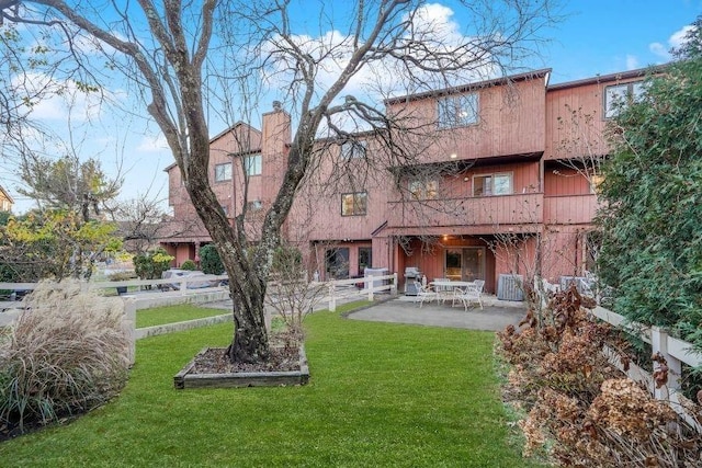 rear view of house featuring a yard and a patio area