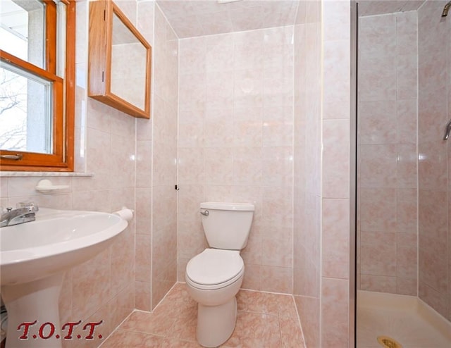 bathroom featuring tile patterned floors, walk in shower, sink, tile walls, and toilet