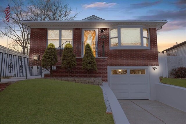 view of front of house featuring a garage and a yard