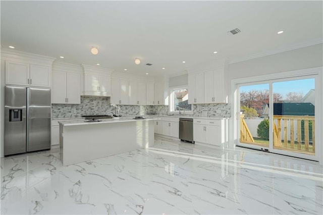 kitchen with plenty of natural light, appliances with stainless steel finishes, crown molding, and white cabinets