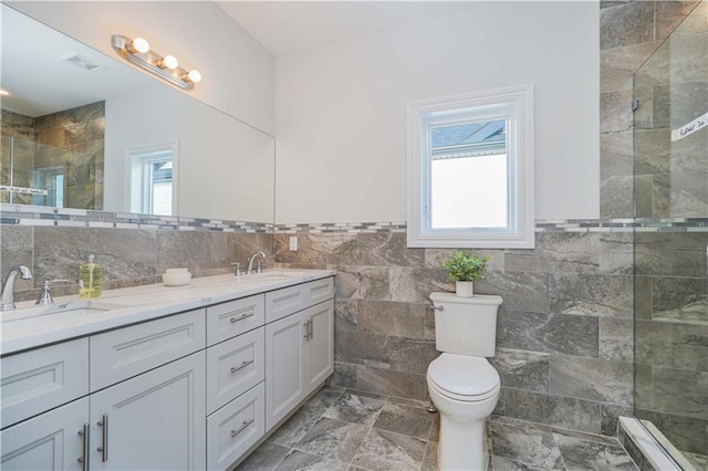 bathroom featuring walk in shower, vanity, tile walls, and toilet