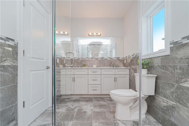 bathroom featuring tile walls, toilet, and vanity