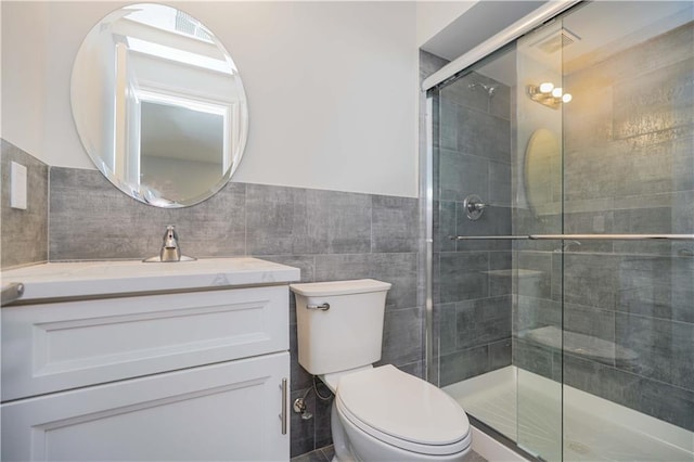 bathroom featuring tile walls, toilet, walk in shower, and vanity